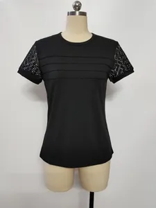 Dettaglio t-shirt nera da donna con maniche in pizzo e design a pieghe sul petto