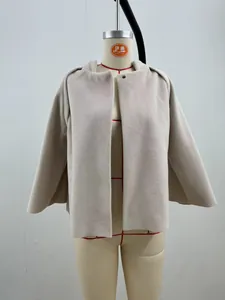 Close-up detail of a minimalist loose short beige cashmere jacket on a mannequin