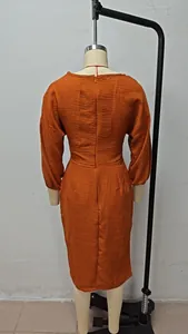 Vue arrière de l'ensemble haut à manches bouffantes orange rouille et jupe midi plissée.