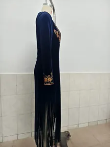 Detailansicht eines marineblauen Samtkleides mit Stickerei und Fransen am Saum