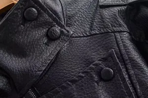 Detailansicht einer schwarzen PU-Lederjacke im Biker-Stil mit strukturierter Narbung und Knöpfen.