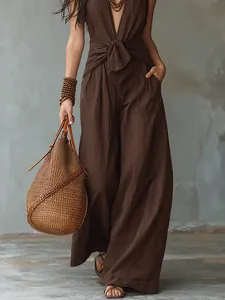Bohemian bruine mouwloze halter jumpsuit met wijde pijpen en strikceintuur detail.