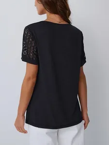 Vista posteriore di una t-shirt nera da donna con eleganti maniche in pizzo traforato.