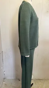Vista lateral de un conjunto de dos piezas en punto acanalado verde con cárdigan y pantalón.