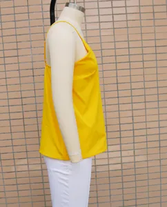 Side profile detail of a bright yellow loose fit V-neck tank top displayed on a mannequin.