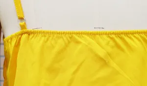 Detail view of the yellow camisole top strap attachment and the fine stitching quality