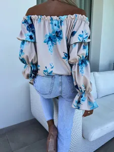 Détail de la vue arrière d'une blouse à volants et imprimé floral bleu col bardot