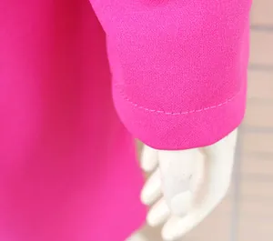 Dettaglio del polsino della manica di un abito blazer rosa acceso da donna.