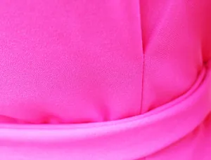 Primo piano del tessuto rosa acceso e dei dettagli di cucitura dell'abito blazer