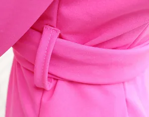 Macro dell'abito blazer fucsia che mostra cuciture fini e dettagli del passante della cintura