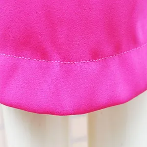 Dettaglio ravvicinato dell'orlo e delle cuciture di un abito blazer rosa da donna.