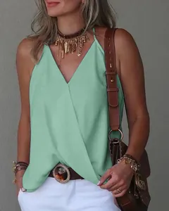 Close-up of a mint green V-neck sleeveless top worn by a model in a casual setting.