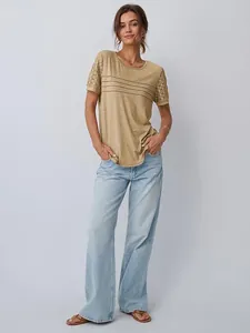 Modella indossa una t-shirt verde oliva ampia con maniche in pizzo