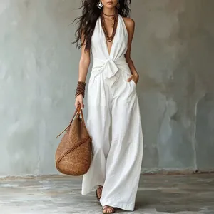 Witte mouwloze halter jumpsuit met wijde pijpen en een stijlvol strikdetail in de taille.