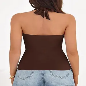 Detail view showing the back of a brown halter-neck top with an elegant tied bow.