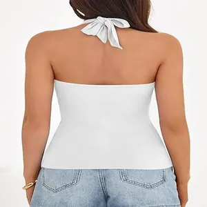 Back view of a white halter-neck top with a tie-back detail and backless design