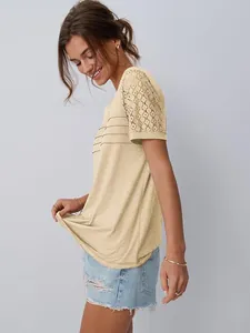 Vista laterale dettagliata di una maglietta beige da donna con pizzo traforato chic