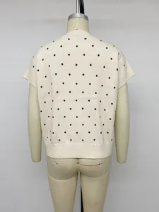 Rückansicht eines weißen kurzärmeligen Strickpullovers mit dunkelblauen Punkten.