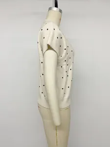 Seitenansicht eines cremefarbenen Damen-Kurzarmstrickpullovers mit dunkelblauen Punkten
