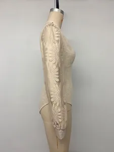 Vista de detalle lateral de un body beige de manga larga con encaje de flores