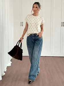 Lässiger weißer Kurzarm-Strickpullover mit schwarzen Punkten und weiten blauen Jeans