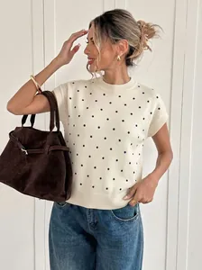 Detailaufnahme eines cremefarbenen kurzärmeligen Strickpullovers mit Punkten für Damen