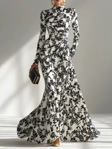 Elegante vestido maxi con estampado floral en blanco y negro, detalles fruncidos y manga larga.