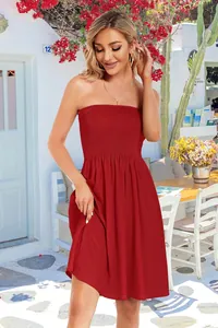 Outdoor detail shot of a red smocked strapless sundress on a female model in summer light