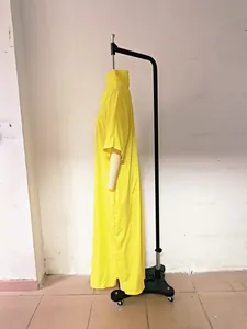Side view macro of a bright yellow short-sleeved loose-fit V-neck maxi dress on a rack