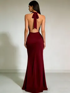 Detail van een elegante bordeauxrode satijnen avondjurk met halternek en open rug ontwerp.