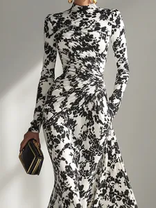 Detalle de vestido de manga larga con cuello alto y estampado abstracto en blanco y negro.