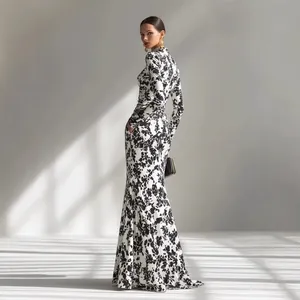 Elegante vestido largo de noche con estampado floral y manga larga en blanco y negro.