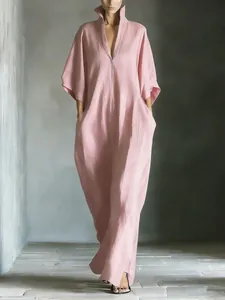 Elegant detail view of a minimalist pink V-neck maxi dress with loose mid-sleeves