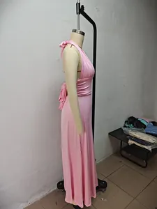 Side profile of a soft pink halter neck maxi dress displayed on a mannequin in a studio