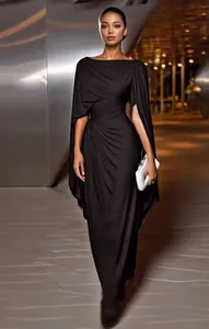 Close-up detail of an elegant black evening gown featuring cape sleeves and draped design