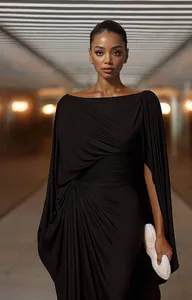 Detailed view of elegant black draped evening gown with cape sleeves and pleats.