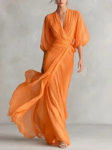 Elegante vestido cruzado naranja con escote en V profundo y falda larga muy fluida.