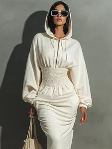 Elegant white hooded long-sleeve dress with cinched waist design shown on a fashion model