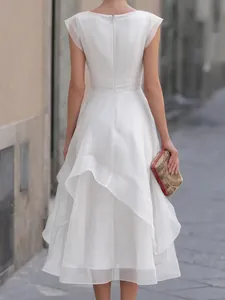 Back detail view of an elegant white mesh dress featuring layered ruffles and zipper