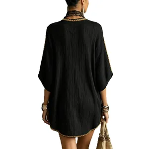 Loose casual black holiday dress with gold braided trim and textured fabric in back view