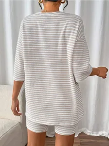 Detail view of the back of a women's beige and white striped knitted two-piece set