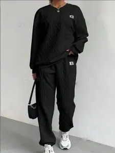 Detalle de conjunto de sudadera y pantalón de chándal de punto trenzado negro mujer