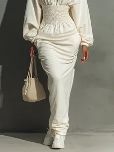 Detail view of cream hooded cinched-waist long-sleeve dress with elegant pleated waist design.