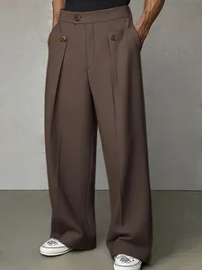 Dettaglio dei pantaloni da abito marroni a gamba larga con design a pieghe da uomo