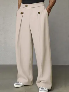 Dettaglio dei pantaloni da uomo beige larghi con doppia abbottonatura e pieghe