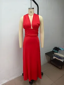 Close-up detail of a red halter neck V-neck long dress with a high-slit design on mannequin