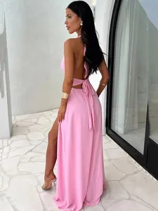Detailed back view of an elegant pink halter-neck maxi dress featuring a sexy high side slit