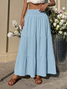 Detail view of light blue high-waisted smocked tiered A-line maxi skirt with textured fabric
