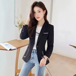 Detail des schwarzen Slim-Fit-Blazers für Damen mit eleganten rosa Kontrastpaspeln.