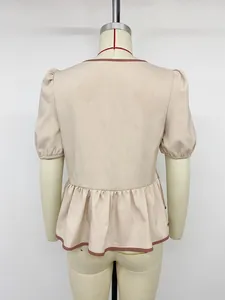 Rückansicht einer beigen Kurzarm-Schößchenbluse mit Kontrastpaspelierung am Mannequin
